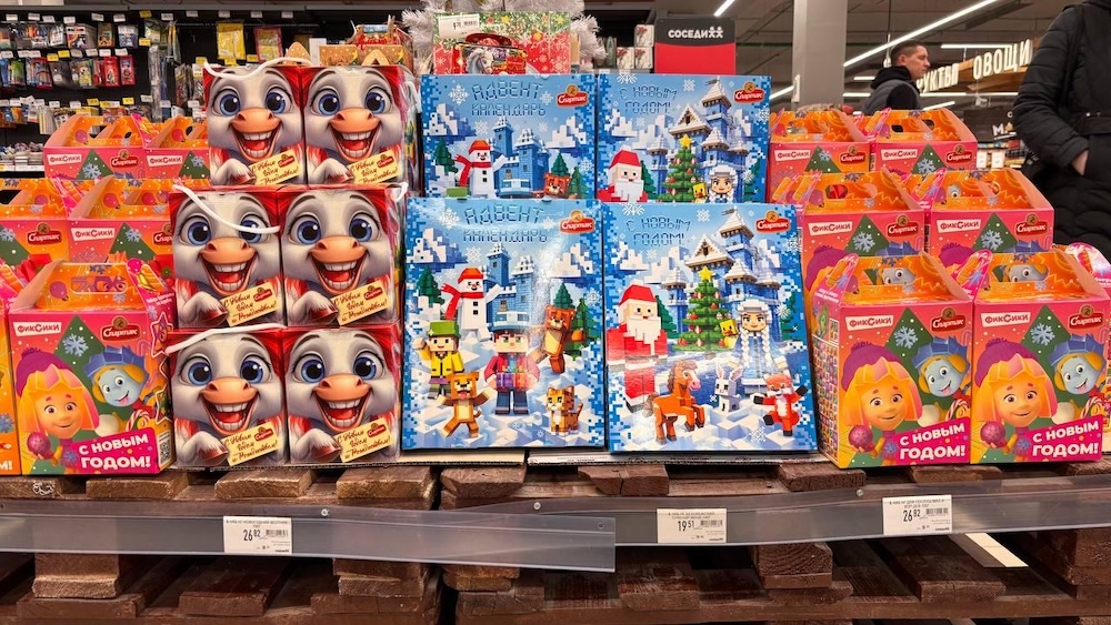Новогодние сладкие подарки на полках в магазине.