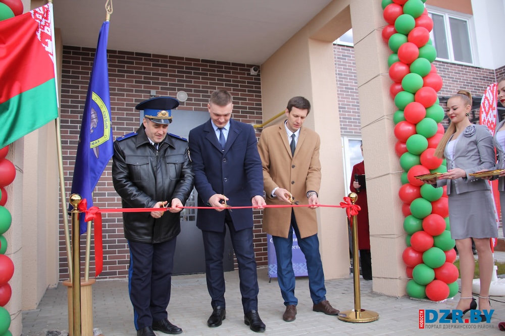 Чиновники перерезают красную ленту на вручении ключей от арендного жилья следователям в Дзержинске